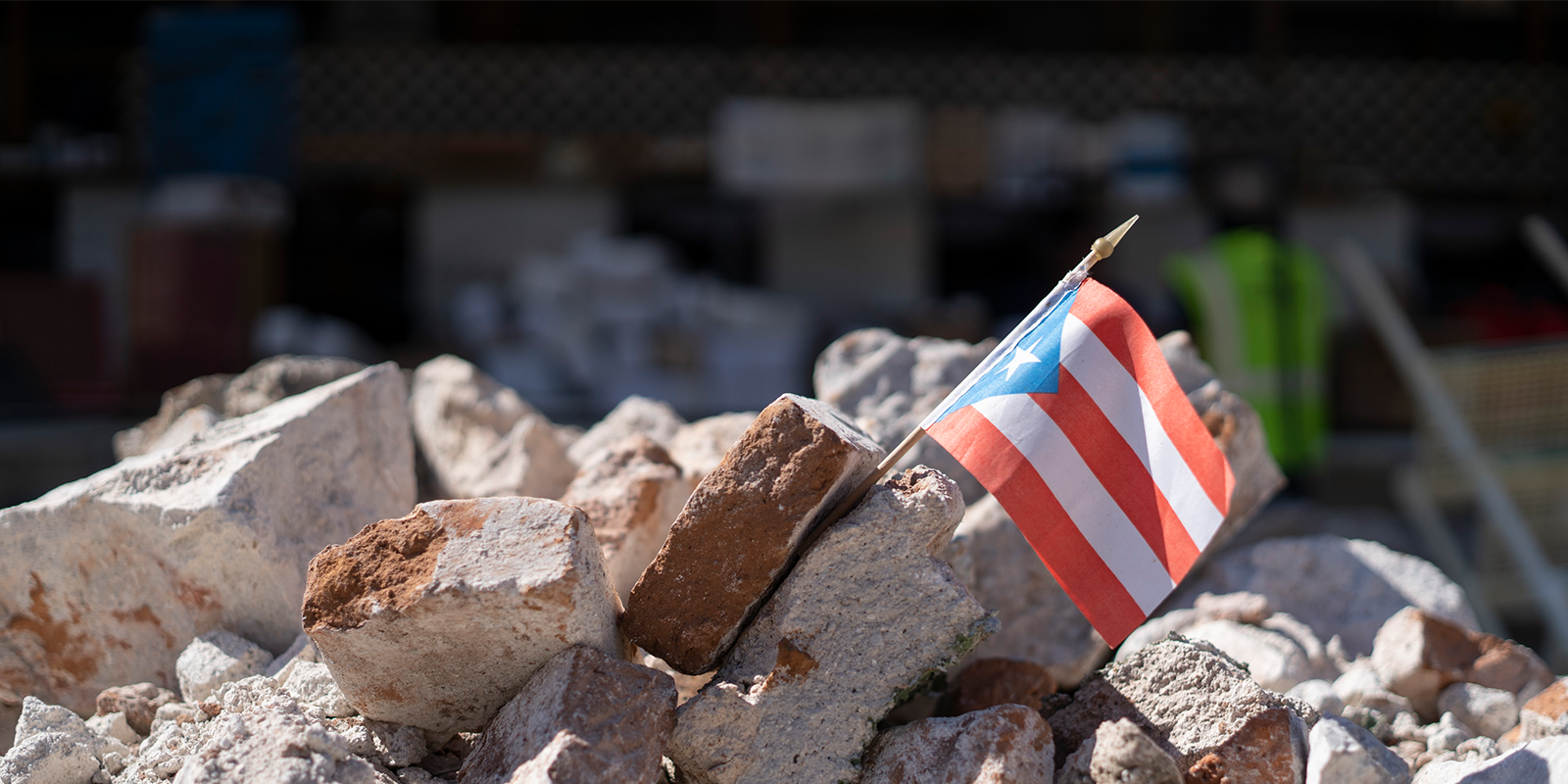 A Puerto Rican flag sits between stone rubble.